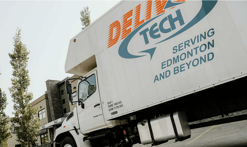 A Delivery Tech FTL and LTL shipping truck parked outside a local business in Edmonton